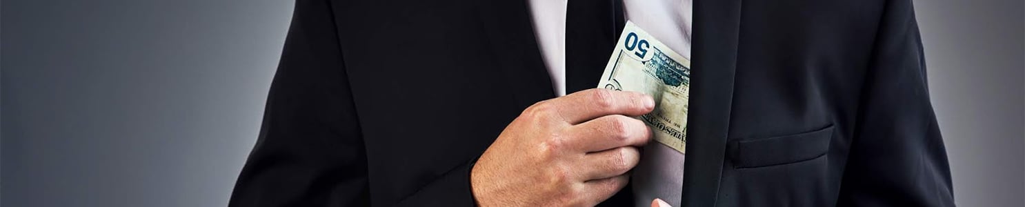 Businessman concealing money in suit jacket [840512460]