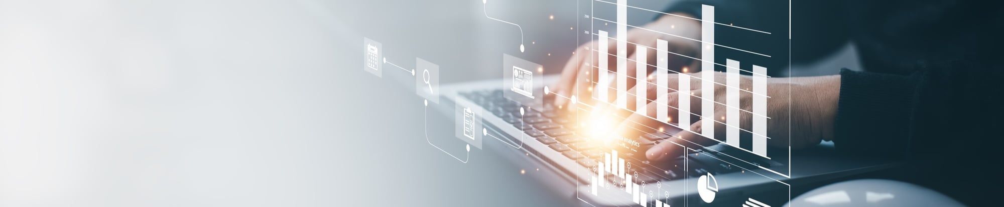 Hands typing on laptop with digital analytics displays and workflow diagrams