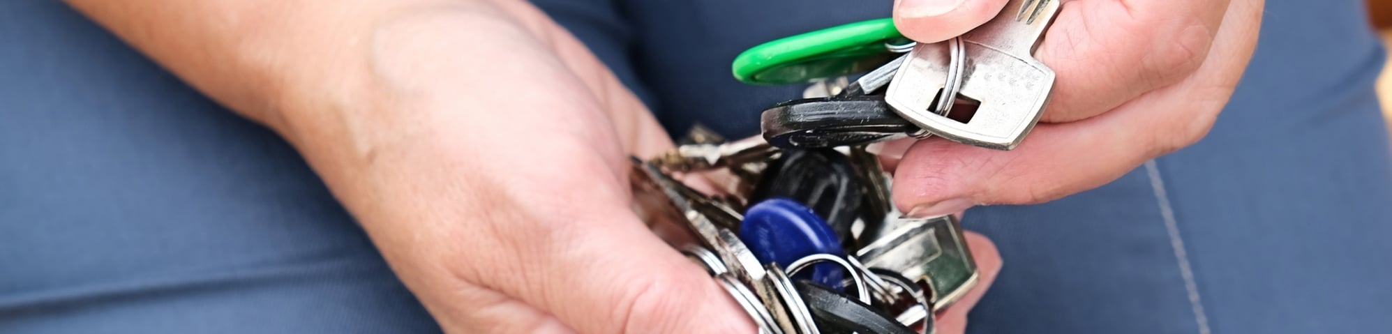Person sorting through handful of keys to find the right one