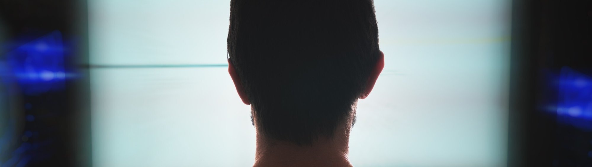 Man looking at lit-up computer screen in dark