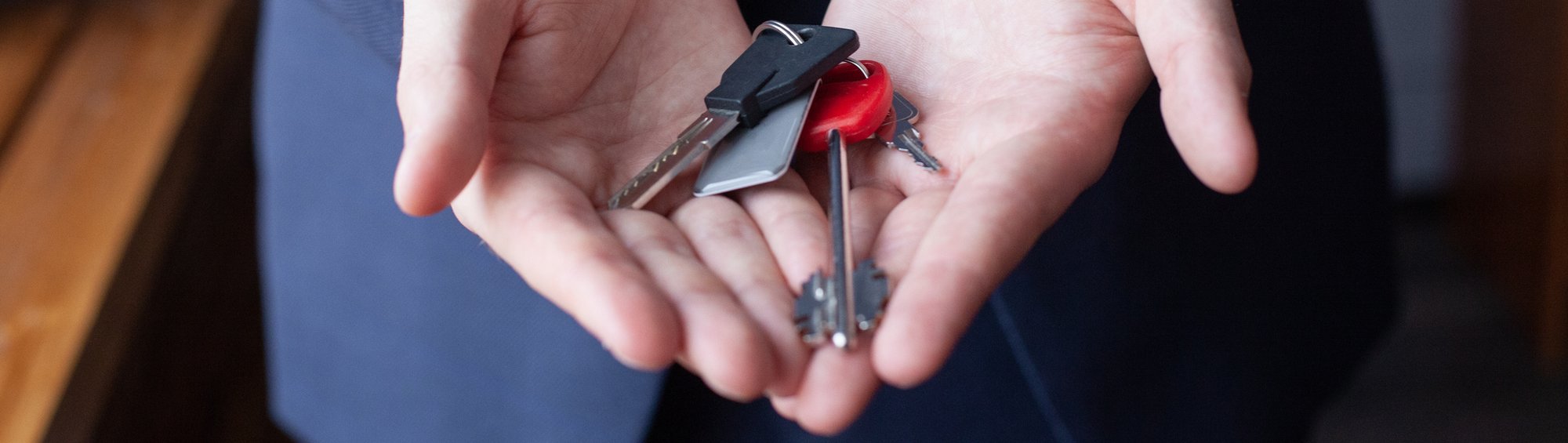 Young businessman holding keys [1406697330]_banner